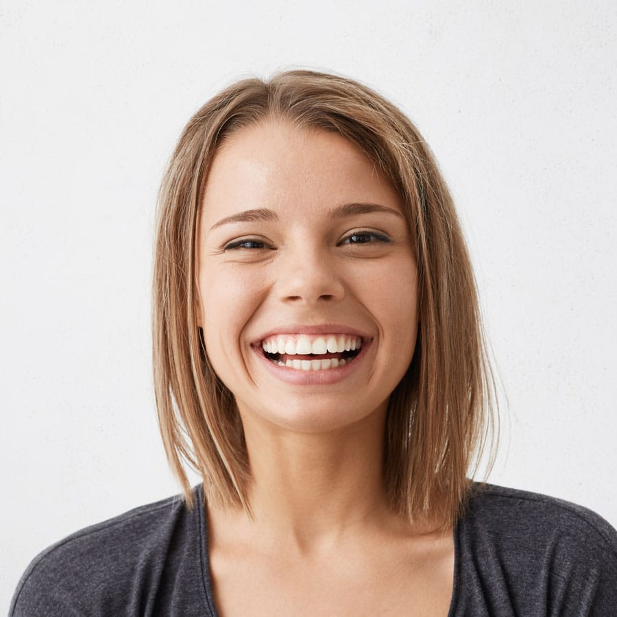 Chica sonriendo tras un tratamiento de encías en la Clínica Julián Saiz de Sevilla